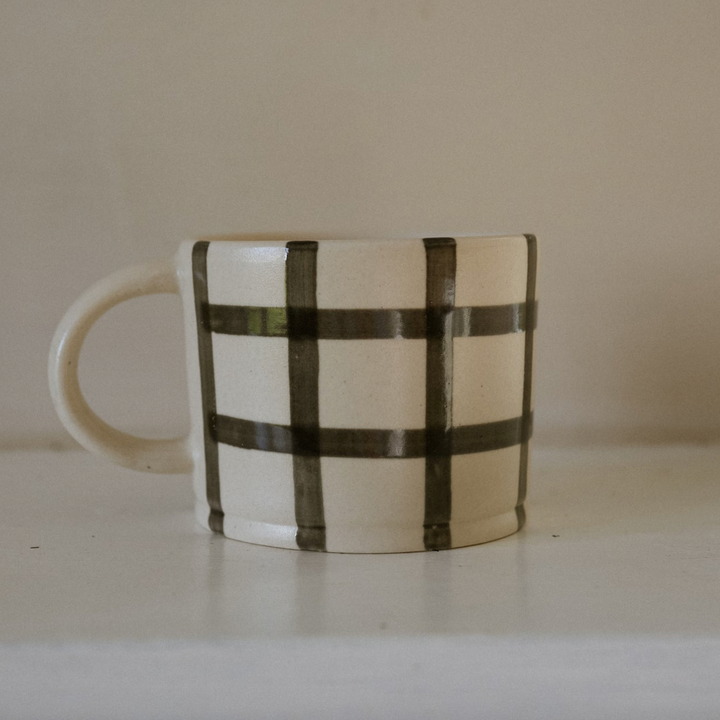 Mug with black checkered pattern on a plain background